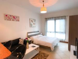 - une chambre avec un lit et un salon avec un canapé dans l'établissement StoneTree - Prime Location - Furnished Studio - Near Metro, à Dubaï