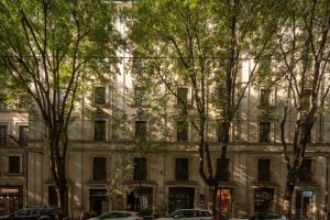 een groot wit gebouw met bomen ervoor bij Monti Design Apartment R&R in Milaan
