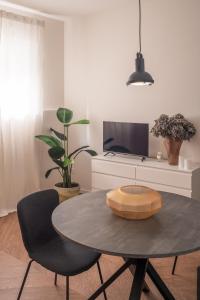 een woonkamer met een tafel en stoelen en een televisie bij Monti Design Apartment R&R in Milaan