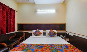 1 dormitorio con 1 cama y 2 sillas en FabHotel Sairam Residency, en Bangalore