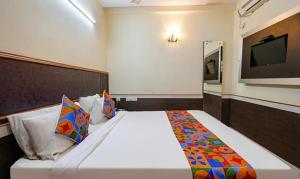 1 dormitorio con 1 cama grande y TV en la pared en FabHotel Sairam Residency, en Bangalore