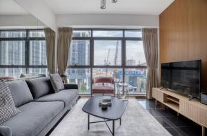 a living room with a couch and a large window at The Majestic Mile 1BR Apartment in Singapore! in Singapore