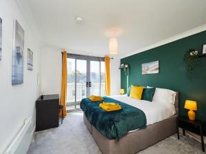 a bedroom with a large bed with a green wall at Emerald Suite - Two Story Duplex Apartment - Contractors - Family - Business - City Centre - Sleeps 6 in Birmingham