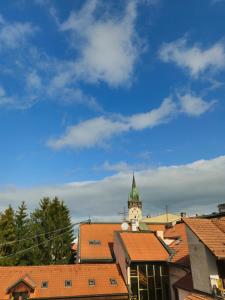 a clock tower on top of a city with roofs at Apartmány NATIVE in Prešov