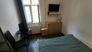 um quarto com uma cama, uma televisão e uma janela em Aradi Rooms with Private bathroom em Budapeste