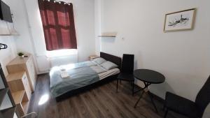 a small bedroom with a bed and a table at Aradi Rooms with Private bathroom in Budapest