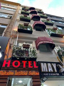 イスタンブールにあるタクシム イスティクラル スイーツのホテルの看板が横に建つ建物
