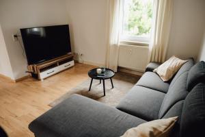 sala de estar con sofá y TV de pantalla plana en Idylische Ferienunterkunft, en Heitersheim