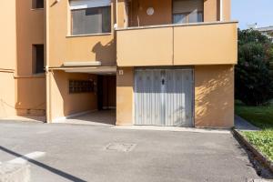 ein Gebäude mit einer Garage mit einer Tür in der Unterkunft Cisanello Lovely Apartment in Pisa in Pisa