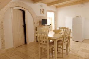 La cuisine est équipée d'une table, de chaises et d'un réfrigérateur. dans l'établissement DOMUS PRAETORIA, à Alberobello