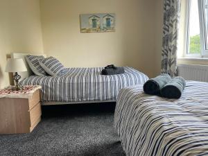 - une chambre avec 2 lits jumeaux et une fenêtre dans l'établissement NEW-4 Bdrm-6 quality beds-2 full bathrm-1 bath-3 vehicle forecourt-washer-dryer-Biz WiFi, à Corby