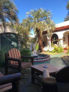 a patio with a bench and a fountain and palm trees at Fortin de Santa Rosa in Atlántida