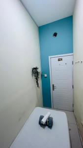 a room with a white bed and a blue wall at Small Private Partition Room in Al Barsha 1 Near Metro in Dubai