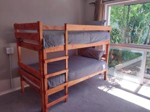 kilka łóżek piętrowych w pokoju z oknem w obiekcie Serenity Shores Backpackers w Kapsztadzie