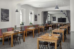 a restaurant with wooden tables and chairs and a tv at Hotel Orlík in Teplice nad Metují