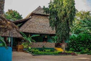 a small house with a thatched roof at Royal Wonders Hotel in Moshi