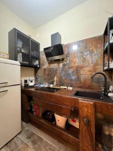 a kitchen with a counter with two sinks and a refrigerator at A due passi da in Formia