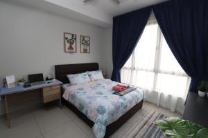 a bedroom with a bed and a desk with a computer at Bali Residence Impian Raudah in Melaka