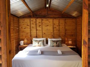 1 dormitorio con 1 cama en una habitación de madera en Old Mill Drift Guest Farm, en Clarens
