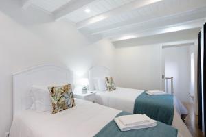2 camas en una habitación blanca con paredes blancas en Adega do Portinho Velho, en Piedade