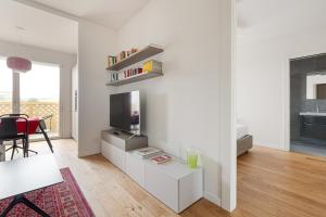 a white living room with a tv and a table at Amazing & Central Milan Apt - City Life District! in Milan