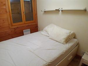 una piccola camera da letto con un letto bianco e una finestra di Appartement Samoëns, 3 pièces, 4 personnes - FR-1-629-48 a Samoëns
