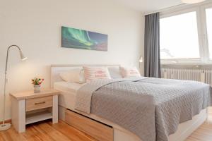 a white bedroom with a bed and a window at Kammerweg 5, Nordlicht in Scharbeutz