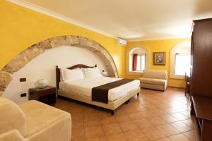 a hotel room with a bed and a chair at Il Duomo in Siracusa