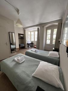 a hotel room with two beds and a table at H&ocirc;tel Patricia - Strasbourg Hyper Centre in Strasbourg