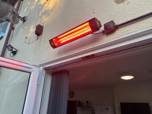 une lumière rouge sur le plafond d'une maison dans l'établissement NEW-4 Bdrm-6 quality beds-2 full bathrm-1 bath-3 vehicle forecourt-washer-dryer-Biz WiFi, à Corby