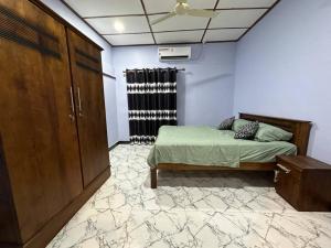 ein Schlafzimmer mit einem Bett und einem Schrank in einem Zimmer in der Unterkunft Villa in Kalviyankadu 