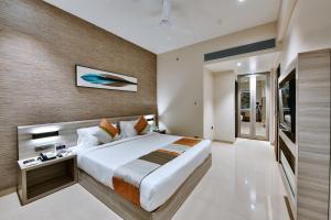 a bedroom with a large bed in a room at Click Hotel Pithampur in Mhow