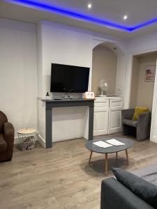 een woonkamer met een tafel met een televisie erop bij gites des cigognes in Duinkerke