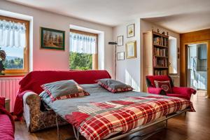 a bedroom with a bed and two chairs at Casa Magda in Tesero