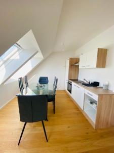 uma cozinha com uma mesa de vidro num quarto em Home Sweet Home Vienna - Penthouse em Viena