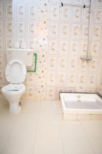 a bathroom with a toilet and a bath tub at Bekam Hotel in Keruguya