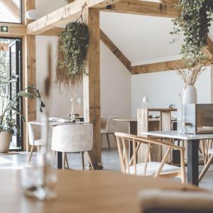 a dining room with wooden tables and chairs at Op Oost Boutique hotel & Restaurant het Kook Atelier in Oosterend