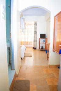 um quarto com um corredor e piso em azulejo em Bekam Hotel em Keruguya