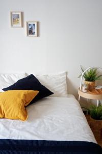 a white bed with a yellow pillow on it at 51st Prosper Building - Vacation STAY 14245 in Nagoya