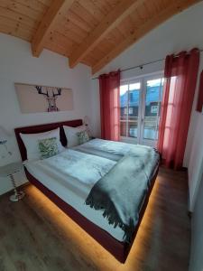 a bedroom with a large bed with red curtains at Hochalmbahnen Chalets Rauris 1-01 Maislaufeldweg 1a in Rauris