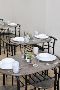 a wooden table with plates and glasses on it at Johal Mini Hotel -Birmingham City-FREE BREAKFAST in Birmingham