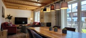 a living room with a large wooden table and chairs at Hochalmbahnen Chalets Rauris 1-01 Maislaufeldweg 1a in Rauris