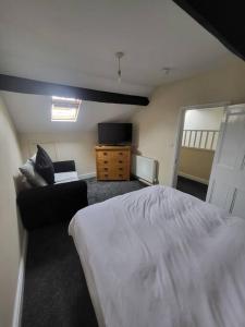 um quarto com uma cama, uma cadeira e uma televisão em The Dublin Packet Apartment em Holyhead