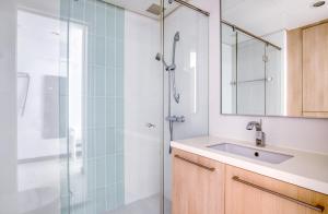 La salle de bains est pourvue d'une douche, d'un lavabo et d'un miroir. dans l'établissement The Radiant Retreat 2BR apartment in Singapore, à Singapour