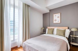a bedroom with a large bed and a large window at The Radiant Retreat 2BR apartment in Singapore in Singapore