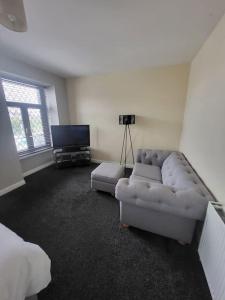 a living room with a couch and a tv at The Dublin Packet Apartment in Holyhead