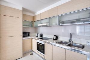 a kitchen with wooden cabinets and a sink at The Radiant Retreat 2BR apartment in Singapore in Singapore