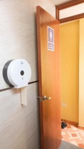 a bathroom door with a toilet paper dispenser on the wall at Confortable habitación doble frente al Aeropuerto in Lima