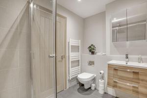 a bathroom with a toilet and a sink and a shower at Contemporary 2 BR apt, town centre by tent serviced apartments in Chertsey