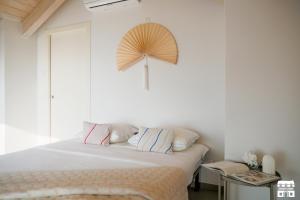 1 dormitorio con 1 cama y ventilador en la pared en ALTOPIANO by Design Studio, en Bellano